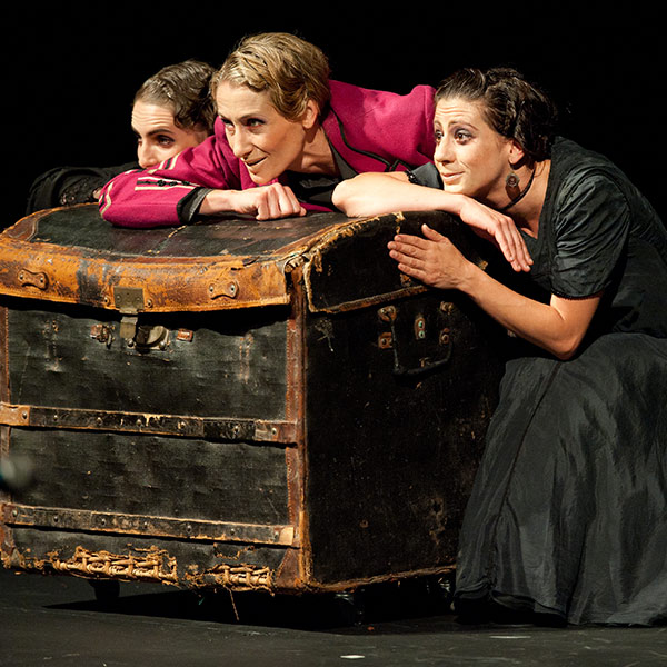 three women leaning on a trunk